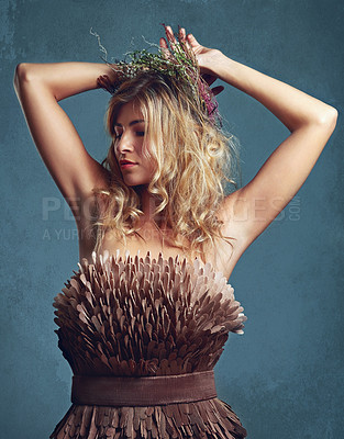 Buy stock photo Nature, fashion and creative woman with flowers in crown in hair and dress with feathers in studio. Natural, style and inspiration from environment for clothes in fantasy cosplay or model in costume