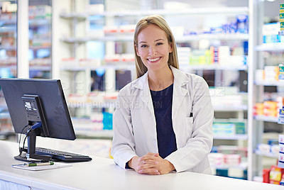 Buy stock photo Portrait of an attractive pharmacist standing at the prescription counter