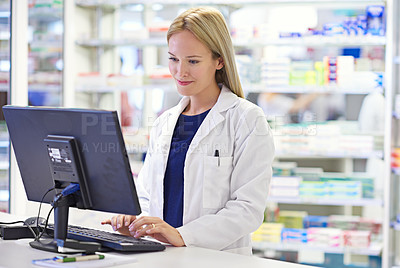 Buy stock photo Shot of an attractive pharmacist using a computer