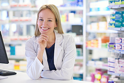 Buy stock photo Portrait of an attractive pharmacist standing at the prescription counter