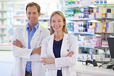 Buy stock photo Portrait of two pharmacists standing at the prescription counter