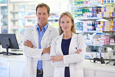 Buy stock photo Portrait of two pharmacists standing at the prescription counter
