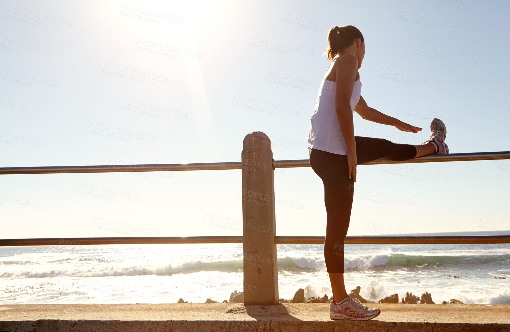 Buy stock photo A young female runner stretching her muscles before a training session