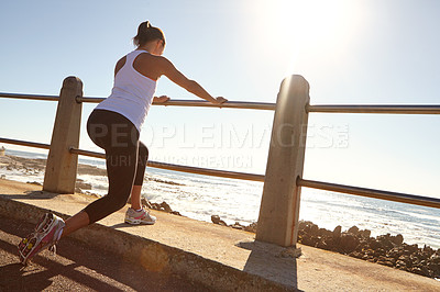 Buy stock photo A young female runner stretching her muscles before a training session