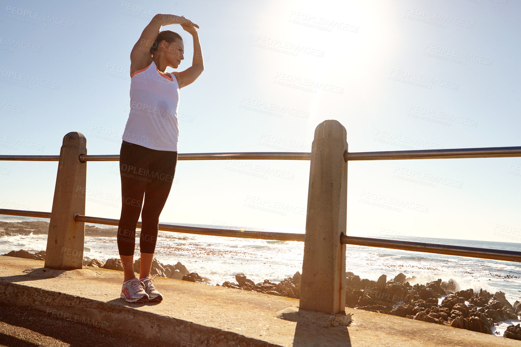 Buy stock photo A young female runner stretching her muscles before a training session