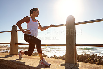Buy stock photo A young female runner stretching her muscles before a training session