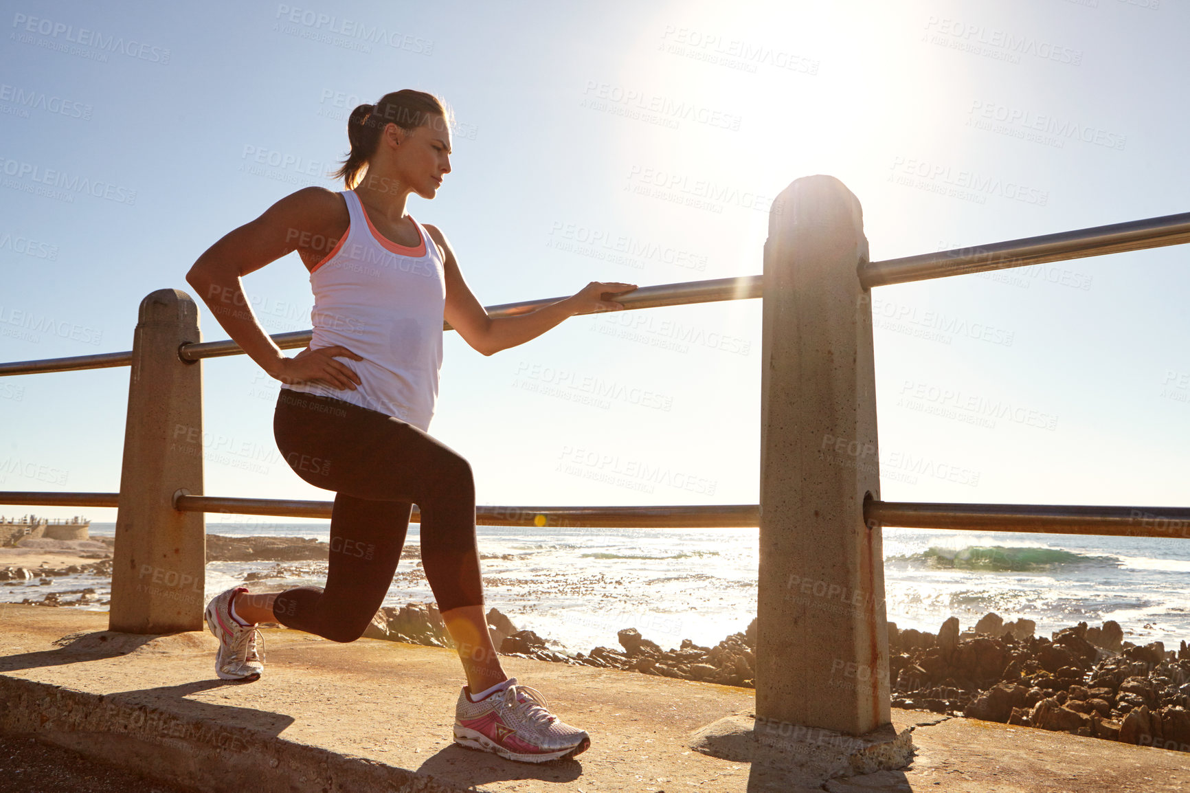 Buy stock photo A young female runner stretching her muscles before a training session