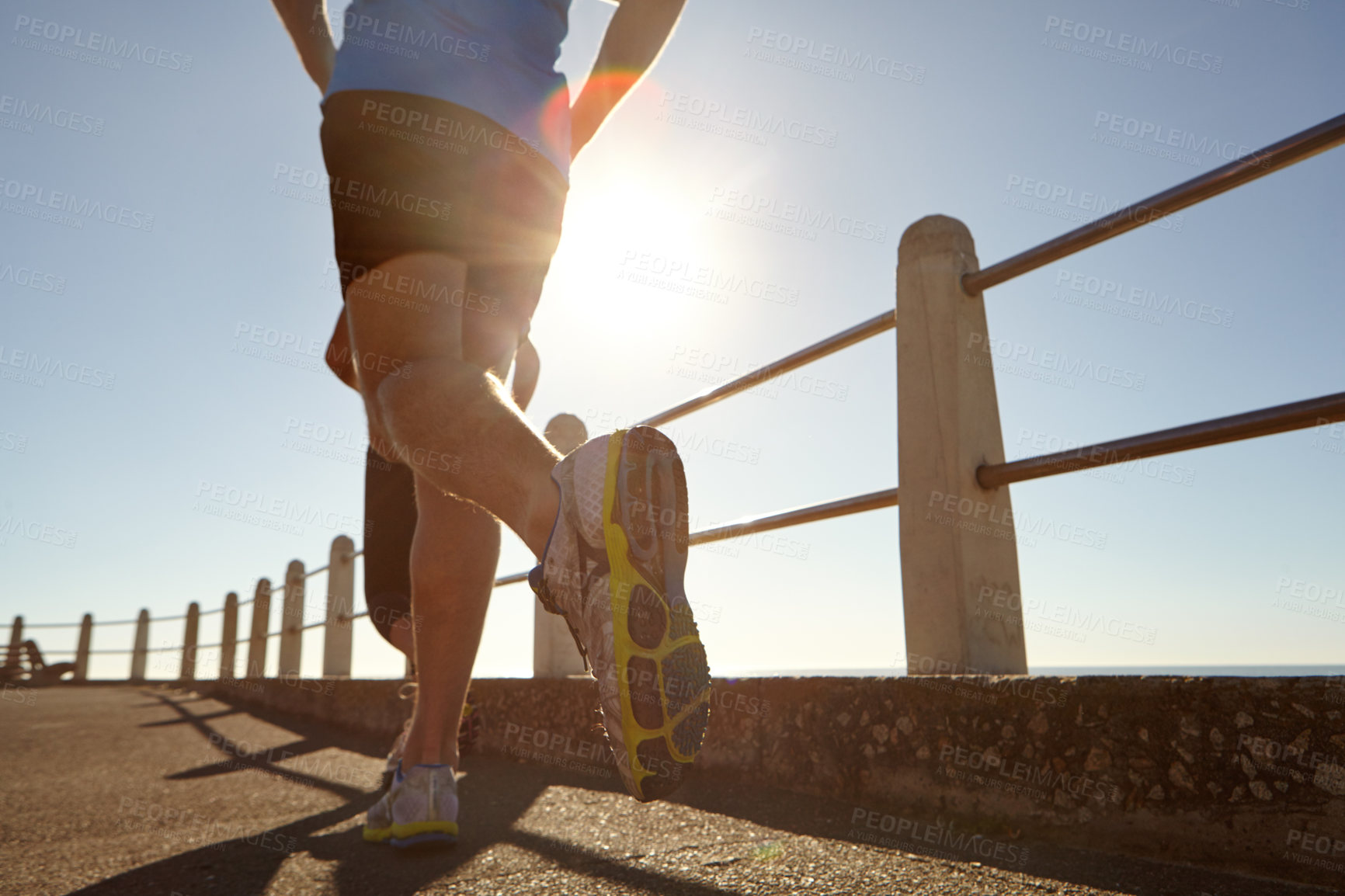 Buy stock photo Cropped shot of two people jogging on the promenade