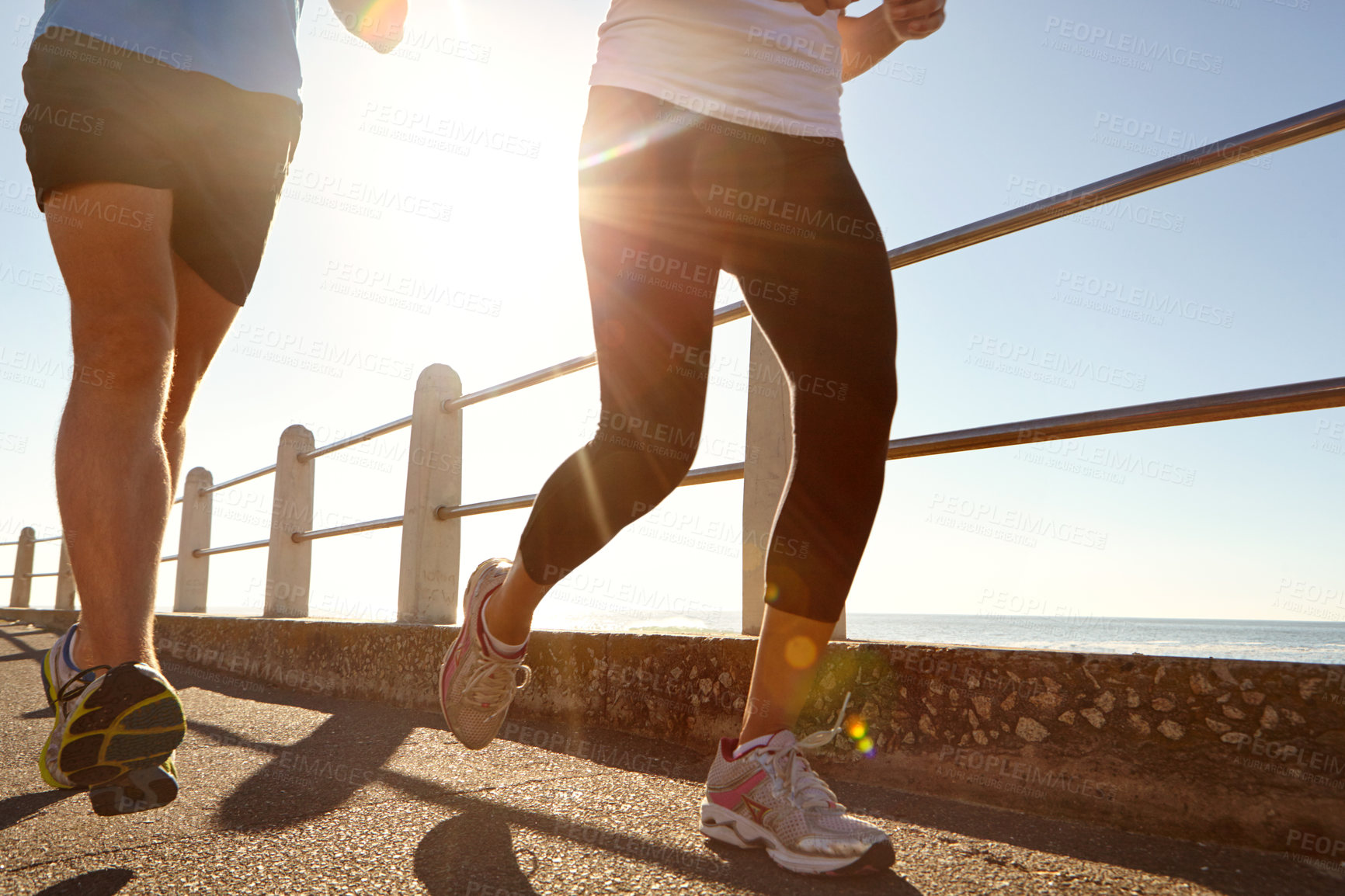 Buy stock photo Cropped shot of two people jogging on the promenade