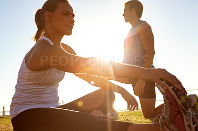 Buy stock photo Shot of a man and a woman stretching on the grass