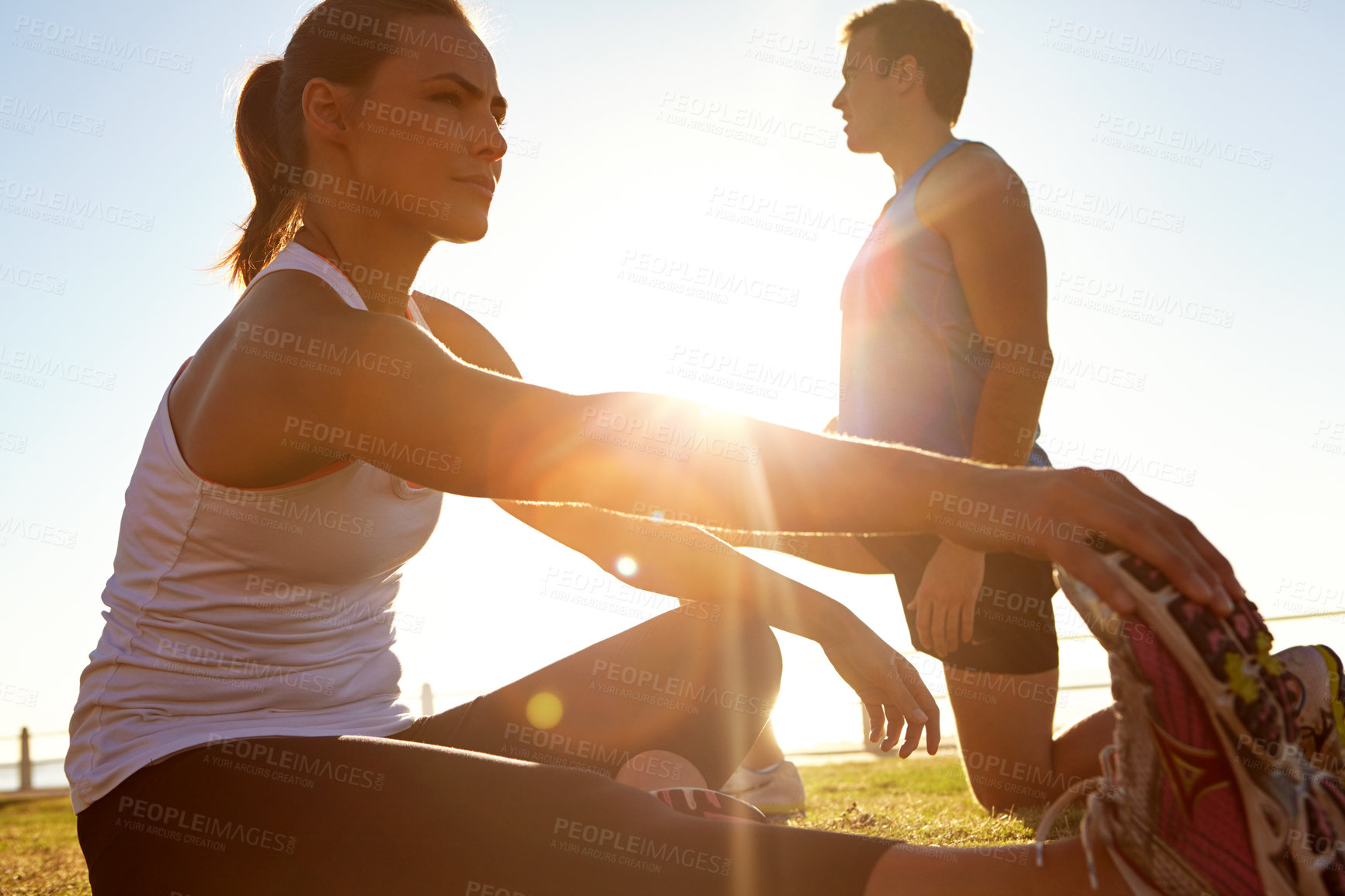 Buy stock photo Shot of a man and a woman stretching on the grass