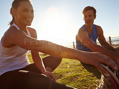 Buy stock photo Shot of a man and a woman stretching on the grass