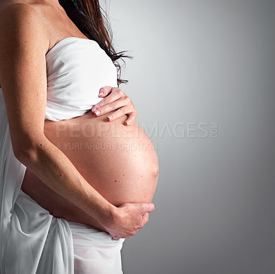 Buy stock photo A pregnant woman holding her tummy