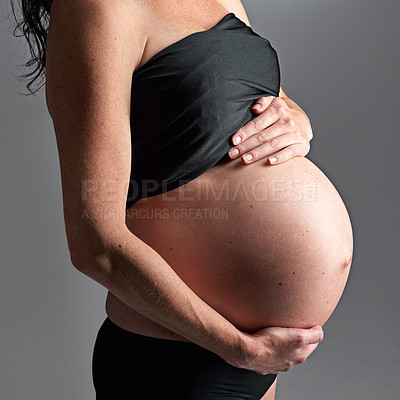 Buy stock photo Studio, pregnant and hands with care for stomach, growth and health of baby, body and glow with cosmetics. Grey background, mom and child in belly or abdomen, shine and skincare for parent and skin