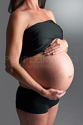 Buy stock photo A pregnant woman holding her tummy