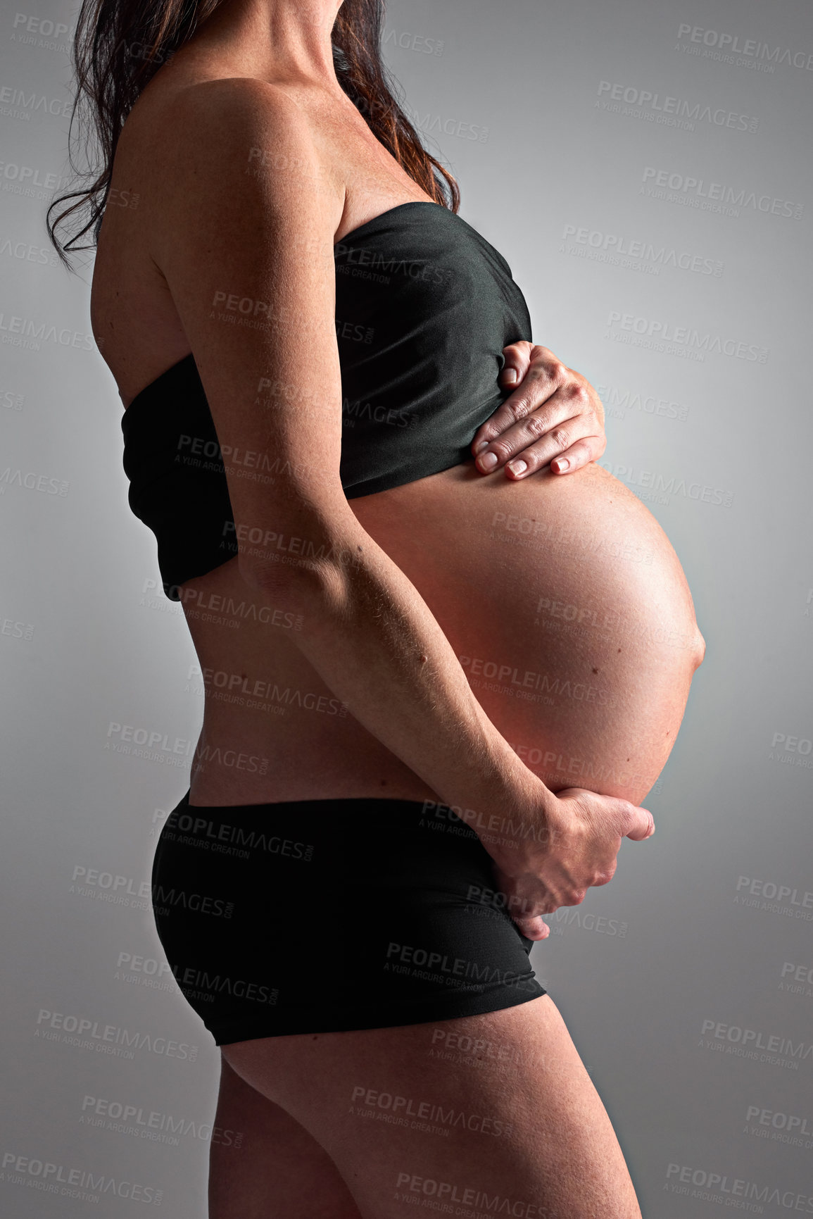 Buy stock photo Studio, pregnant and person with stomach, healthy and growth of baby, body and glow with cosmetics. Grey background, mom and child in belly or abdomen, shine and skincare for woman and love of parent