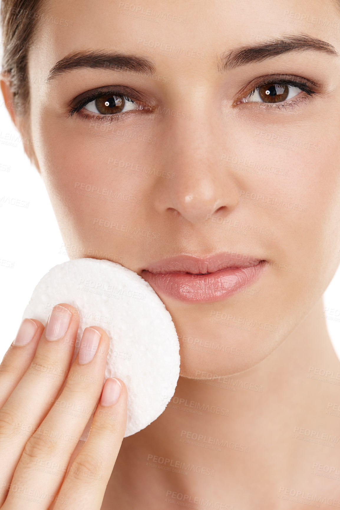 Buy stock photo Cropped portrait of a beautiful young woman exfoliating her face against a white background