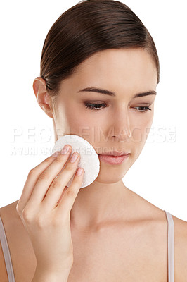 Buy stock photo Cropped shot of a beautiful young woman exfoliating her face against a white background