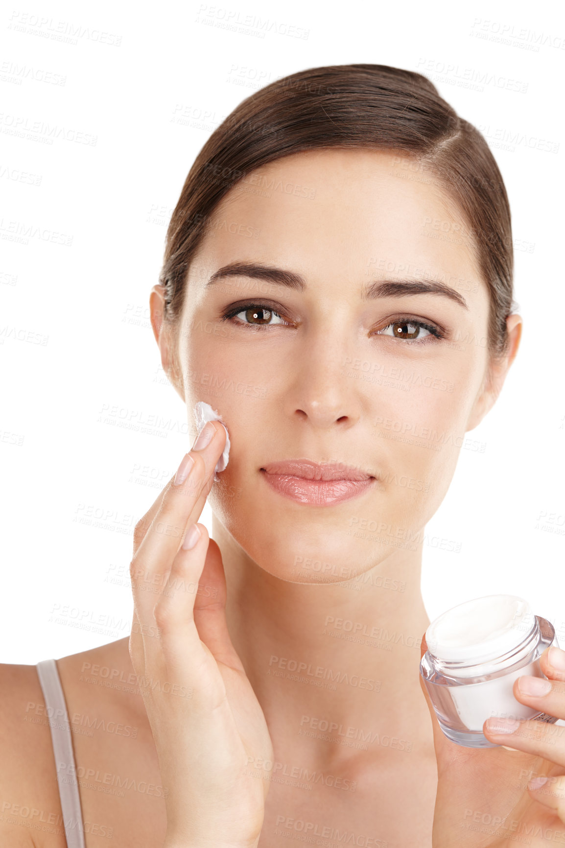 Buy stock photo Cropped portrait of a beautiful young woman applying moisturizer against a white background