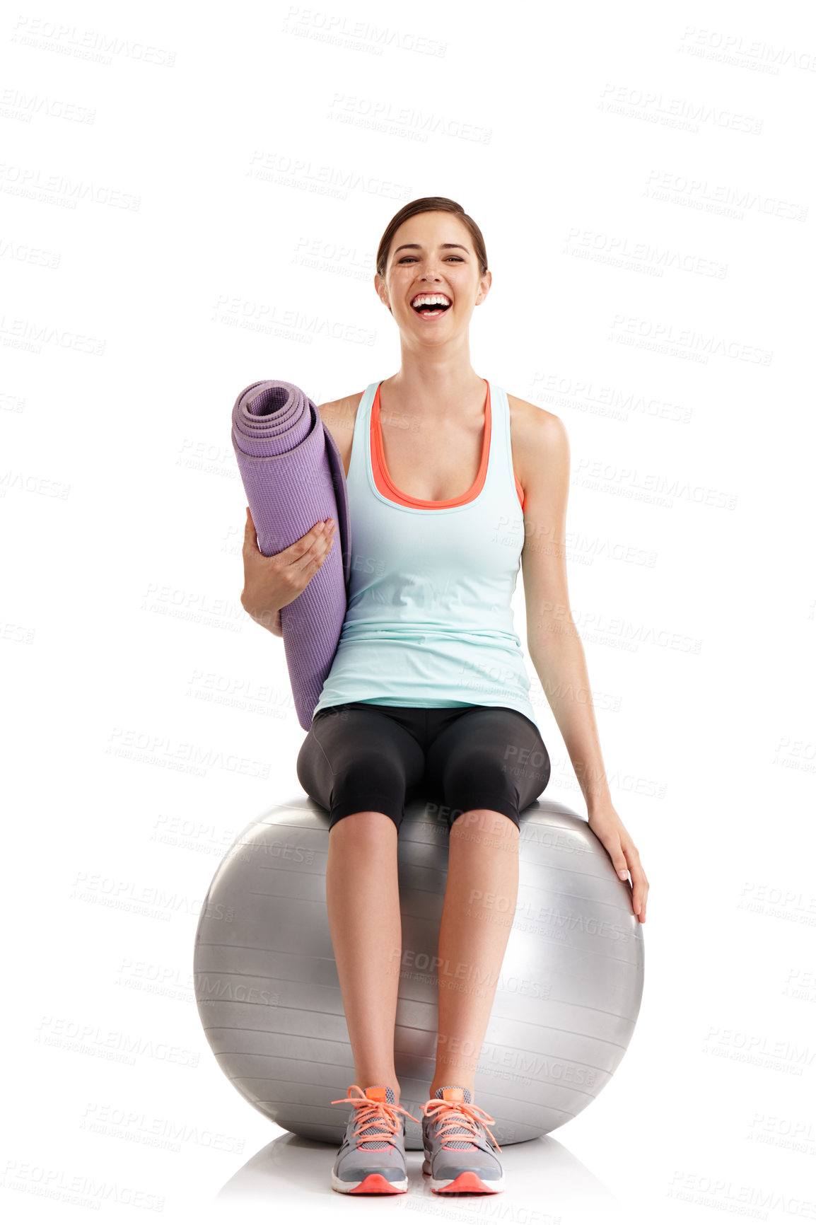 Buy stock photo Shot of a young woman holding a yoga mat while sitting on a exercise ball