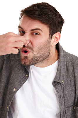 Buy stock photo Closeup studio portrait of a young man holding his nose and suggesting an unpleasant smell