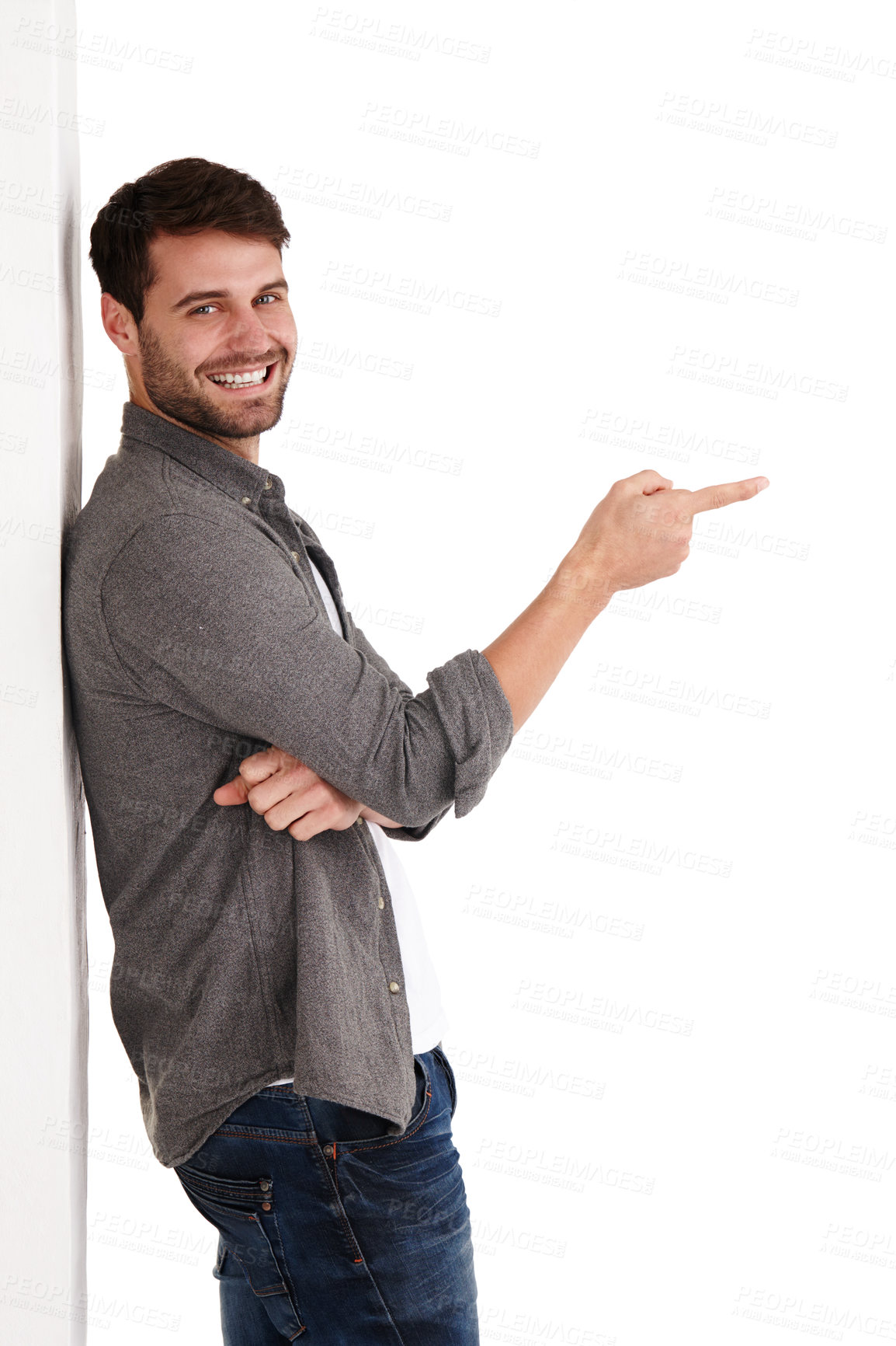 Buy stock photo Studio shot of a smiling young man pointing at copyspace to the right