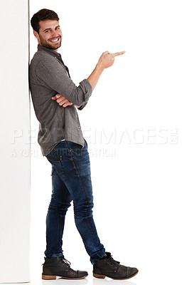 Buy stock photo Full length studio shot of a smiling young man pointing at copyspace to the right