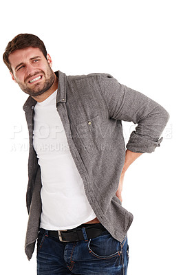 Buy stock photo Studio shot of a young man grimacing in pain while holding his back