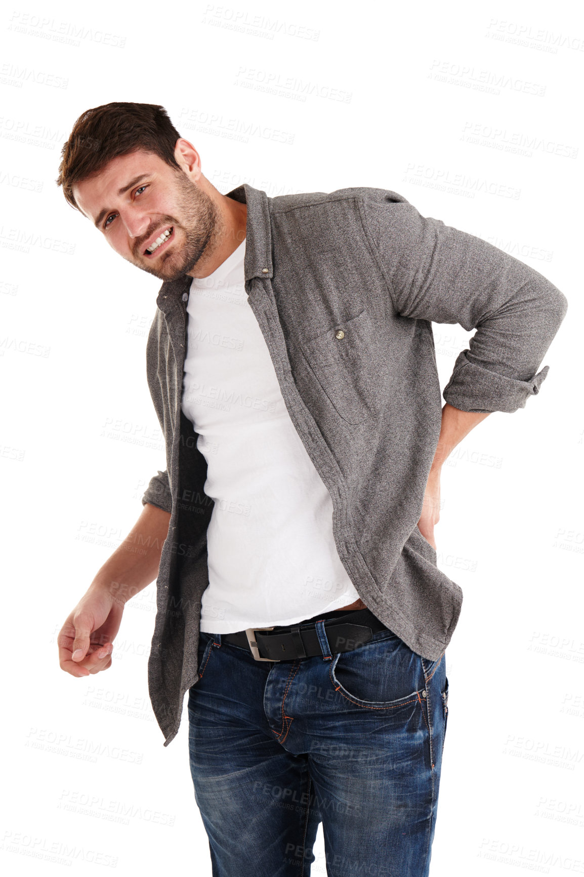 Buy stock photo Studio shot of a young man grimacing in pain while holding his back