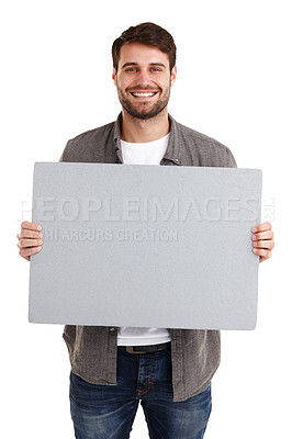 Buy stock photo Studio portrait of a smiling young man holding up a blank poster 