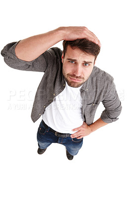 Buy stock photo High-angle shot of a young man in studio looking guilty and regretful