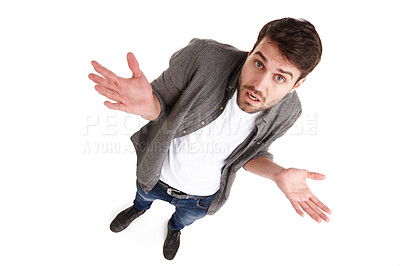 Buy stock photo High-angle shot of a young man in studio holding up his hands looking innocent