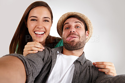 Buy stock photo Self portrait of a happy young couple in studio having fun together