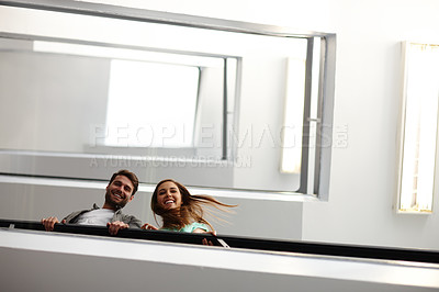 Buy stock photo Shot of two people in stairwell smiling while looking down at you
