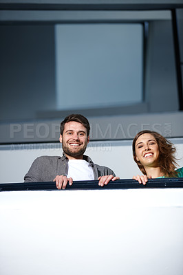 Buy stock photo Shot of two people in stairwell smiling while looking down at you