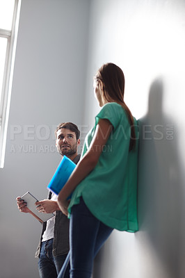Buy stock photo Low angle shot of two people having a conversation in a stairwell