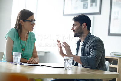 Buy stock photo Shot of a young man having a serious discussion with his manager