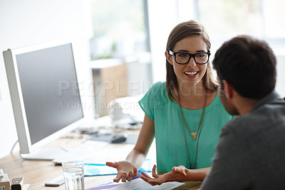 Buy stock photo Shot of a young designer explaining something to a colleague