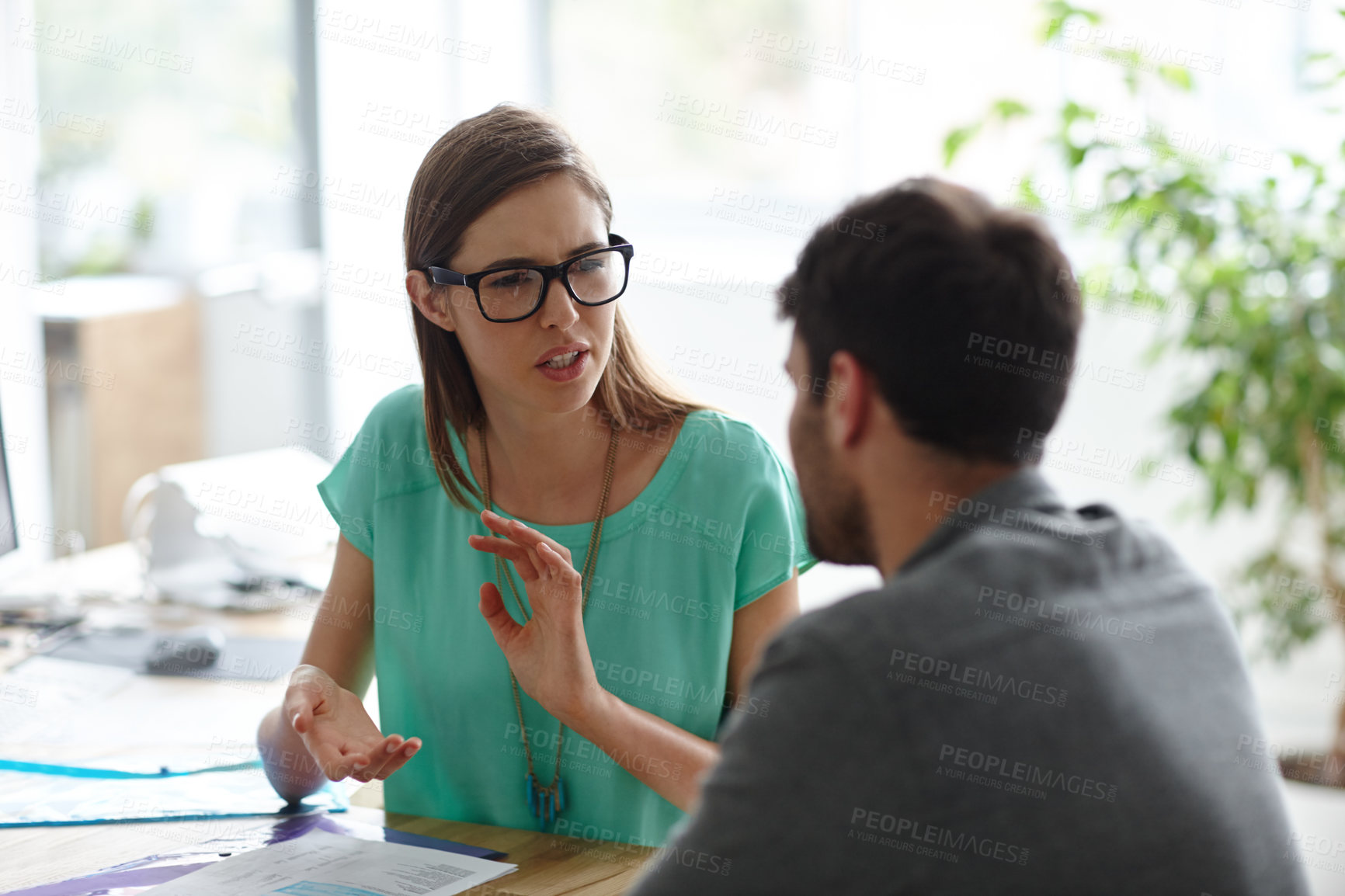 Buy stock photo Shot of a young designer explaining something to a colleague