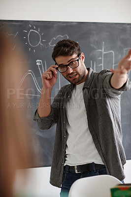 Buy stock photo Shot of a young man presenting information on a blackboard