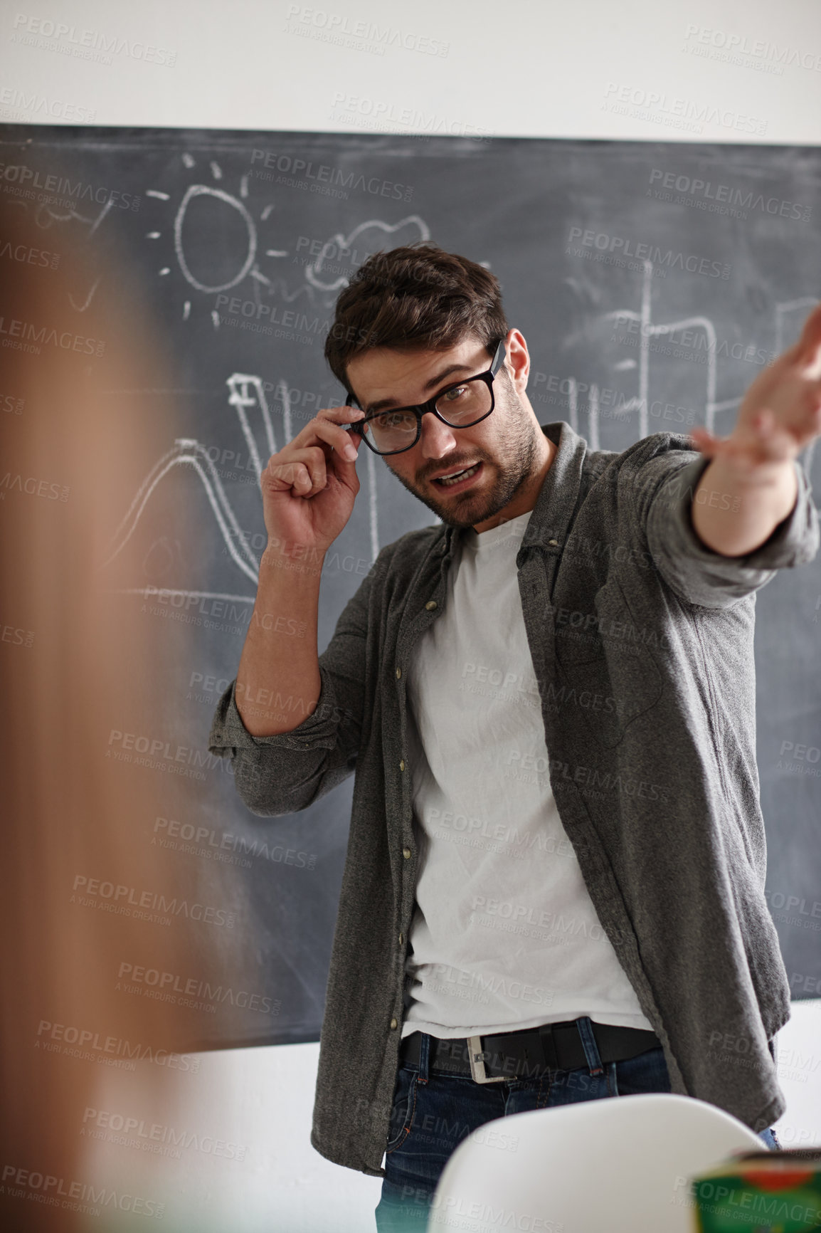 Buy stock photo Shot of a young man presenting information on a blackboard