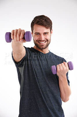 Buy stock photo Studio portrait of a smiling young man using dumbbells to exercise