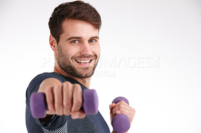 Buy stock photo Closeup studio portrait of a smiling young man using dumbbells to exercise