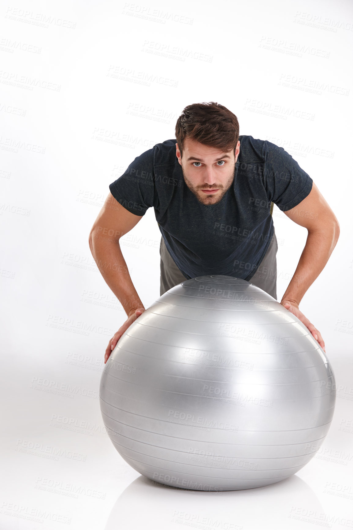 Buy stock photo Studio shot of a young man doing pushups on an exercise ball