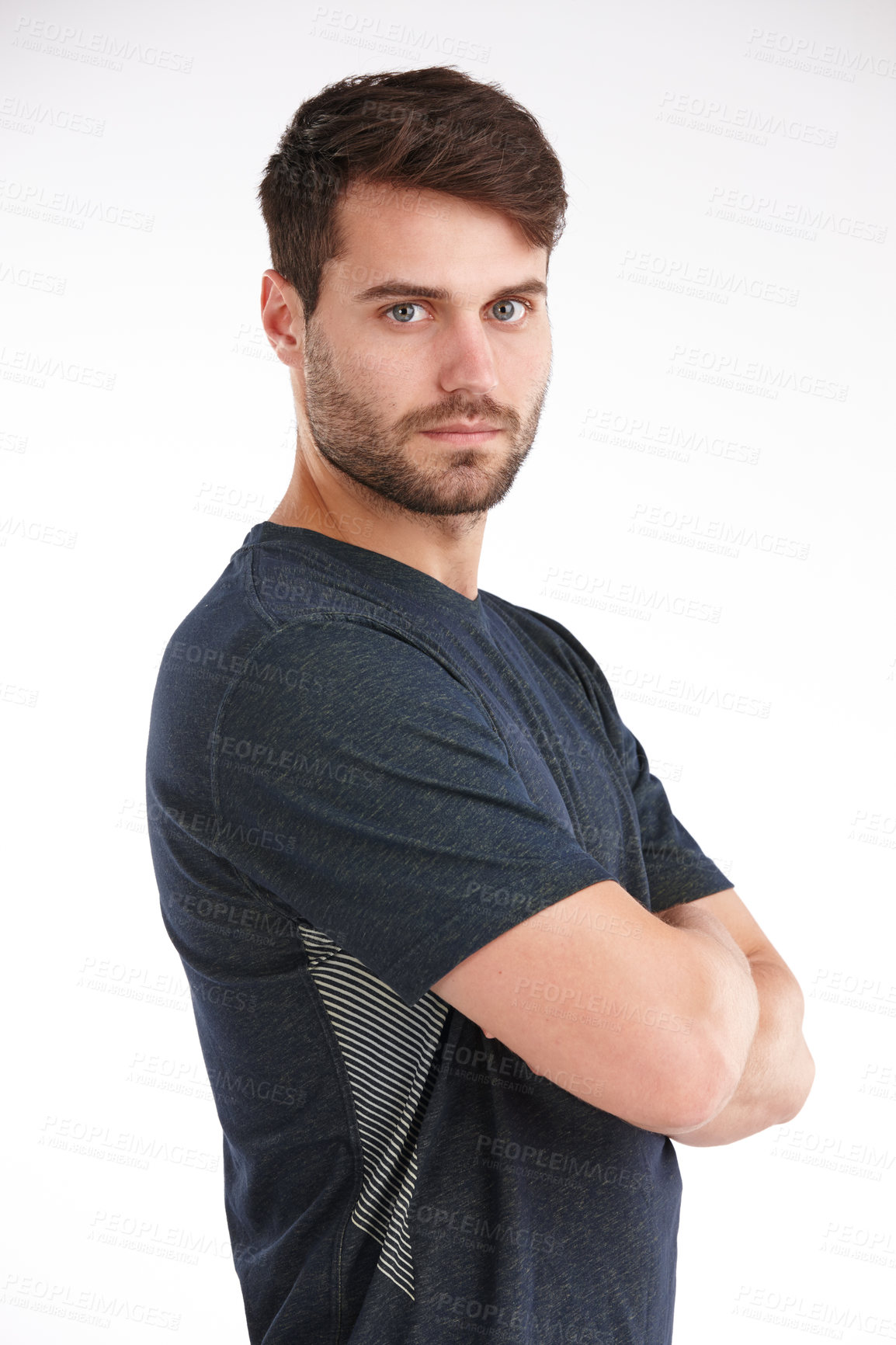 Buy stock photo Studio shot of a serious young man standing with his arms folded