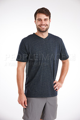 Buy stock photo Studio shot of a smiling young man standing casually with his hand on his hip