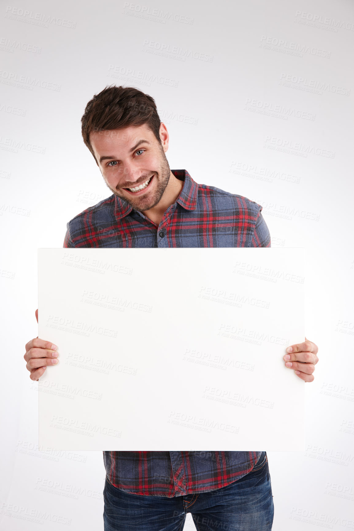 Buy stock photo Studio shot of a smiling young man holding a blank white poster