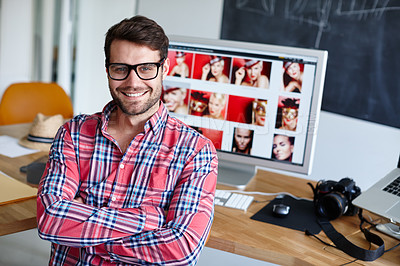 Buy stock photo Portrait shot of a creative professional at his desk with his computer in the background
