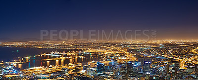 Buy stock photo Lights, buildings and drone of the city at night with urban development, sea water and streets. Dark, travel and aerial view of outdoor residential architecture of downtown with a harbour in evening.