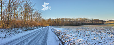 Buy stock photo Winter, countryside and road for travel in snow with nature, forest and blue sky background. Postcard, wallpaper or calendar art for travel, vacation and cold holiday season with street and landscape